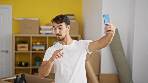 Young hispanic man having video call doing thumb up gesture at new home - Footage, Video