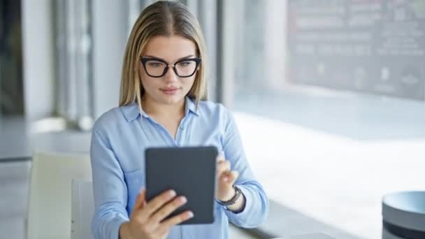 Nuori blondi nainen liike-elämän työntekijä käyttää kannettavaa tietokonetta tekemällä selfie kosketuslevy toimistossa - Materiaali, video