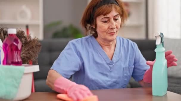 Mujer de mediana edad limpiador profesional de lavado de mesa casa - Metraje, vídeo