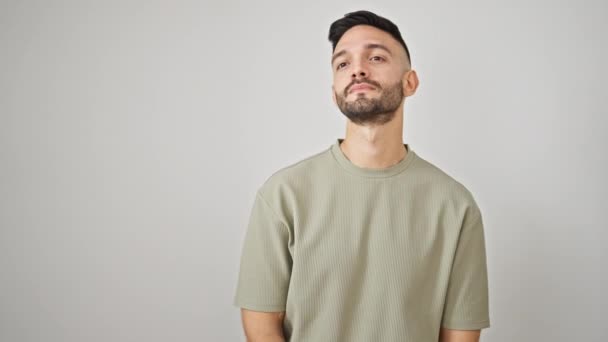 jonge latino man glimlachen zelfverzekerd zeggen hallo met de hand over geïsoleerde witte achtergrond - Video