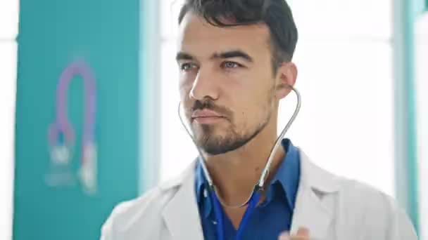 Junger hispanischer Mann untersucht mit Stethoskop in Klinik - Filmmaterial, Video