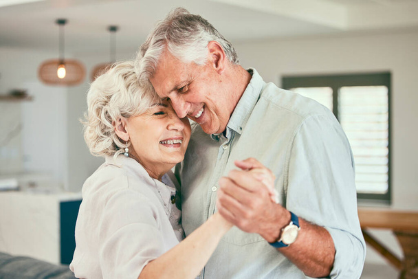 Tomados de la mano, sonreír o feliz pareja de ancianos bailando por amor o alegría en el matrimonio en casa juntos. Abrazo, romántico anciano o anciano vinculación con la sonrisa o el cuidado en la jubilación o sala de estar de la casa. - Foto, Imagen
