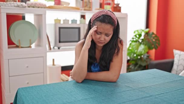 Jonge Chinese vrouw gestrest zittend op tafel in eetkamer - Video