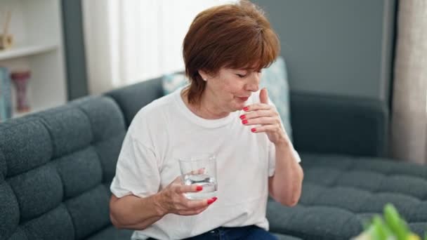 Mulher de meia idade beber copo de água tosse em casa - Filmagem, Vídeo