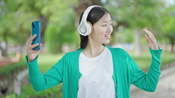 Fiatal kínai nő, akinek videohívás mosolygott a parkban - Felvétel, videó
