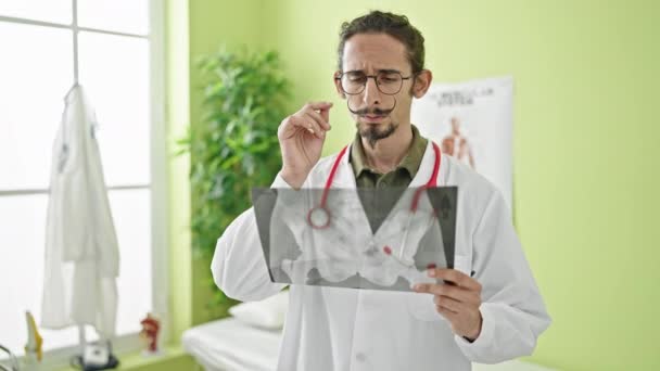Junger hispanischer Mann Arzt sucht Röntgenbild in Klinik - Filmmaterial, Video