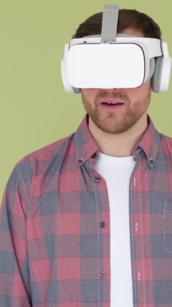 Překvapený muž ve sluchátkách virtuální reality je ohromen tím, co viděl. Používání technologií umělé inteligence s 3D brýlemi. Svislé video - Záběry, video