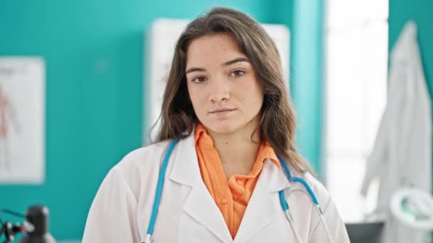 Giovane bella donna ispanica medico sorridente fiducioso in piedi alla clinica - Filmati, video