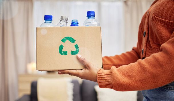 Plastik, Recycling und Hände mit Flasche in Box im Wohnzimmer für umweltfreundlichen, wiederverwendbaren und erneuerbaren Abfall. Nachhaltigkeit, Naturschutz und Menschen mit Behältern zur Verringerung von Abfall, Abfall und Müll. - Foto, Bild