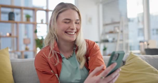 Woman, smartphone typing and laugh on sofa in home, reading social media and app. Face of happy gen z girl scroll on cellphone for funny meme, download mobile games and search network in living room. - Footage, Video