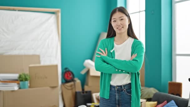 Nuori kiinalainen nainen hymyilee luottavainen istuu sohvalla uudessa kodissa - Materiaali, video
