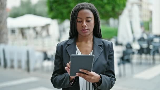 Afroamerykanka kobieta biznes pracownik za pomocą touchpad z relaksującą ekspresją na tarasie kawiarni - Materiał filmowy, wideo