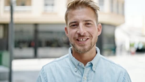 Jonge blanke man glimlacht vol vertrouwen op straat - Video