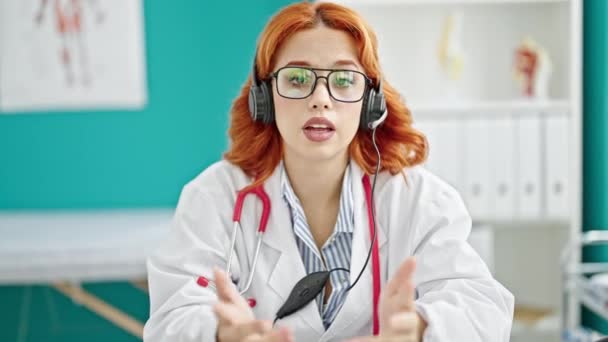 Jeune rousse femme médecin sur appel vidéo à la clinique - Séquence, vidéo