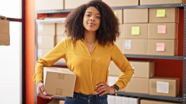 Африканська американська жінка електронної комерції бізнесмен тримає пакет посміхається в офісі - Кадри, відео