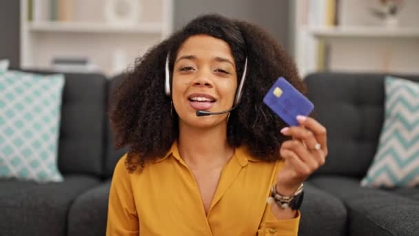 Afrika kökenli Amerikalı kadın çağrı merkezi ajanı elinde kredi kartıyla çalışıyor. - Video, Çekim