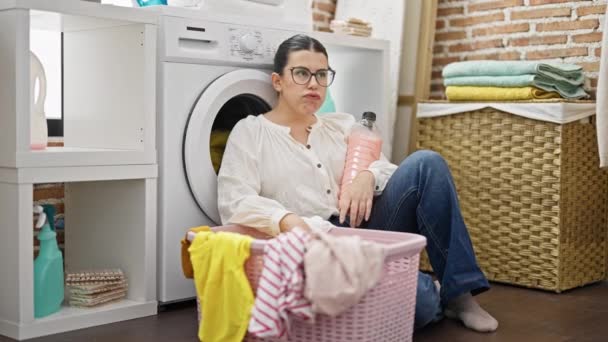 Jovem bela mulher hispânica cansada de lavar roupa na lavanderia - Filmagem, Vídeo