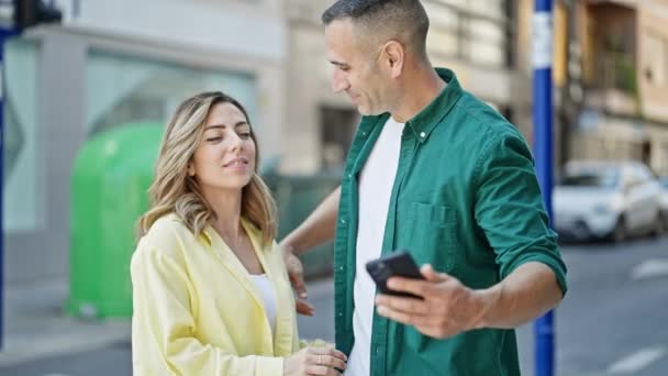 Muž a žena pár objímání navzájem, aby selfie podle smartphone na ulici - Záběry, video