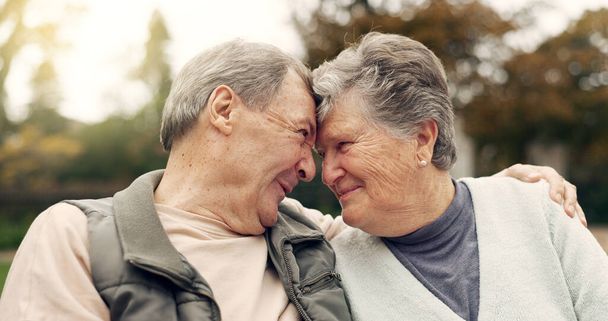 Μέτωπο, άγγιγμα και ηλικιωμένο ζευγάρι σε ένα πάρκο με αγάπη, ευτυχία και συζήτηση με ρομαντικό δέσιμο. Διασκέδαση, ηλικιωμένοι και ηλικιωμένοι αγκαλιάζουν τη γυναίκα με φροντίδα, ειδύλλιο ή αδελφή ψυχή σύνδεση εξωτερική. - Φωτογραφία, εικόνα