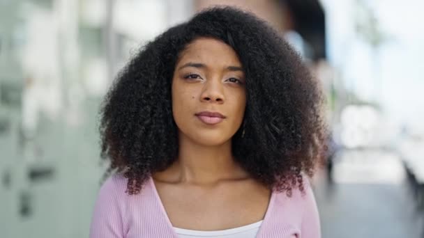 Mujer afroamericana sonriendo confiada haciendo gesto silencioso en la calle - Imágenes, Vídeo