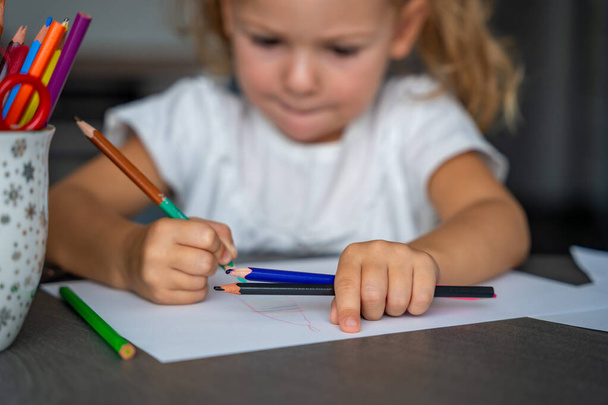 Küçük kız evde renkli kalemlerle resim çiziyor. Yüksek kalite fotoğraf.  - Fotoğraf, Görsel
