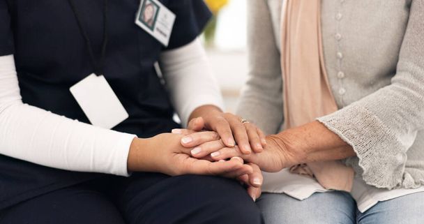 Senior person, holding hands and caregiver empathy, support and elderly care for client with medical problem. Retirement home, wellness and closeup clinic therapist, surgeon or nurse with kindness. - Photo, Image