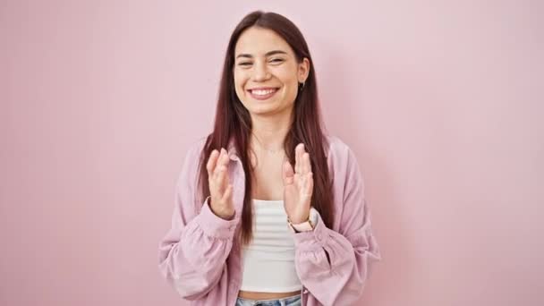 Молодая красивая латиноамериканка улыбается уверенно хлопая аплодисментами над изолированным розовым фоном - Кадры, видео