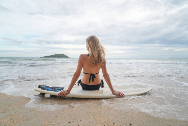 Mujer sexy posa con tabla de surf en la playa - Foto, Imagen