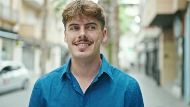 Jonge Spaanse man glimlacht vol vertrouwen op straat - Video