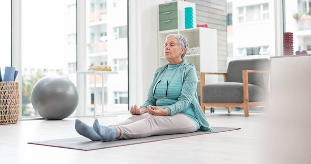 Yoga, meditation and senior woman with mindfulness and training peace, calm or home exercise for wellness. Health, spiritual and elderly person workout for zen mindset or breathing in an apartment. - Photo, Image