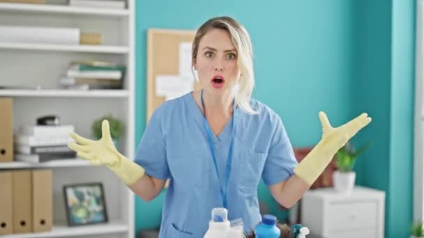 Junge blonde Frau professionelle Reinigungskraft wütend und schreit im Büro - Filmmaterial, Video