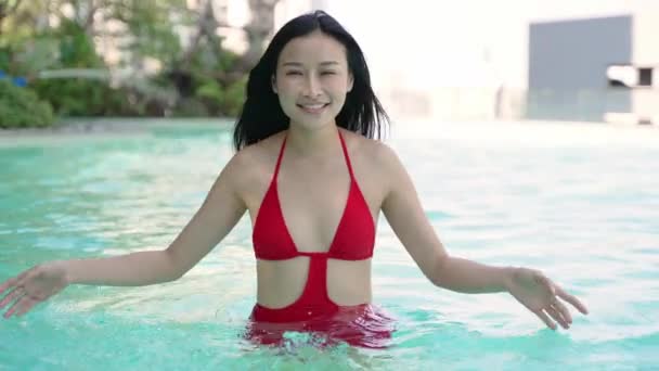Mladá krásná thajská žena v bikinách, usmívá se, užívá si letní dovolenou u bazénu - Záběry, video