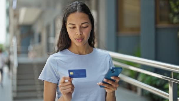 Afrikai amerikai nő vásárol okostelefonnal és hitelkártyával az utcán - Felvétel, videó