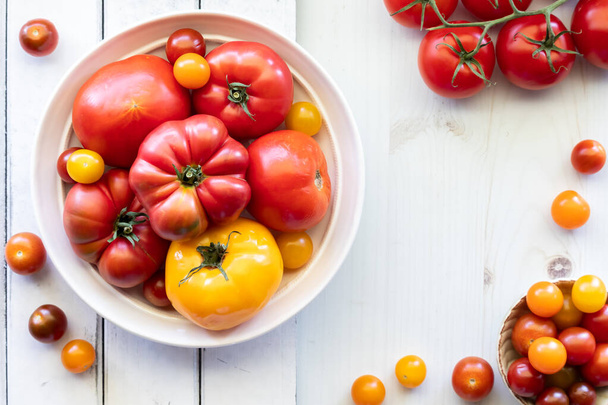 Un tazón de varios tomates frescos y maduros con espacio para copiar a la derecha.  - Foto, Imagen