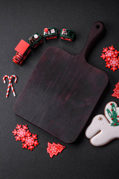 Leere dunkle Keramikteller mit Elementen der Weihnachtsdekoration auf dunklem Betongrund - Foto, Bild