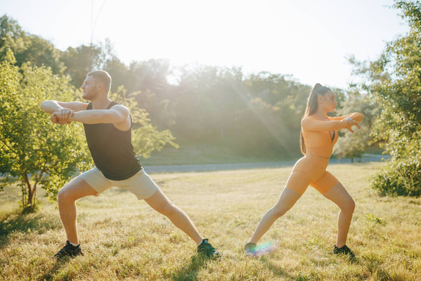 Healthy Lifestyle Active Man and Woman Exercising. Sporty Morning Young Couple Doing Workout at Sunrise, Athleticspirit - Foto, Imagem