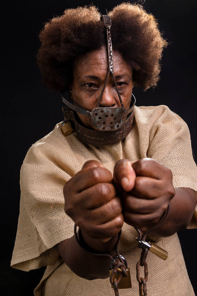 Femme noire enchaînée avec un masque de fer sur le visage, représentant l'esclave Anastacia. tristesse et apathie, douleur. Esclavage au Brésil. - Photo, image