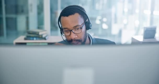 Computer, customer service and support with a black man consultant working in a call center for assistance. Contact, communication and headset with an employee consulting in a telemarketing office. - Footage, Video
