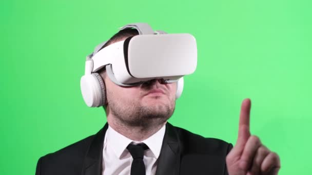 Blanke jonge zakenman met een virtual reality bril, op groene achtergrond in de studio. Verticale video - Video