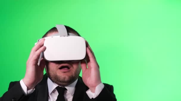 Amerikai munkás virtuális valóság headset zöld háttérrel stúdióban. Technológiai eszközökkel rendelkező projektek irányítása vagy forgalmazása. 4k videó - Felvétel, videó
