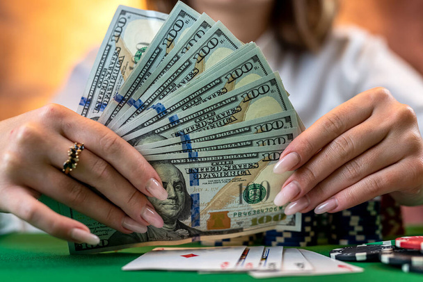 プレーヤーはお金のためのチップをカウントし、カジノポーカーをプレイ中に発生します。ギャンブルの概念。女とポーカーだ。ドレスを着た女性が - 写真・画像