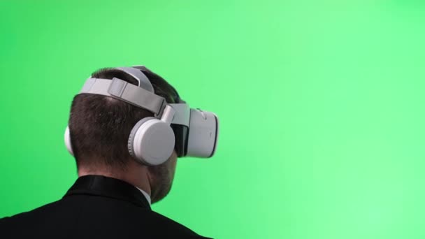 Homem de negócios em óculos de realidade virtual em um fundo cromado. - Filmagem, Vídeo