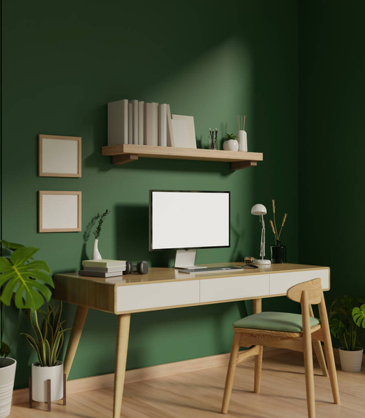 Moderno interior de oficina de moda con una maqueta de pantalla blanca de computadora en una mesa de madera mínima contra la pared verde, una silla, un estante de pared con decoración y plantas de interior. 3d render, ilustración 3d - Foto, imagen