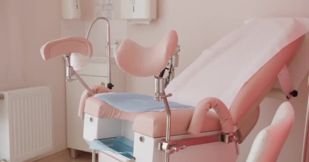 Silla ginecológica en tonos rosados en gabinete privado del hospital. Equipos médicos profesionales para el examen o inspección de mujeres. Concepto de salud - Metraje, vídeo