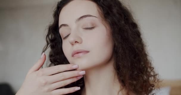 Nainen, jolla on täydellinen terve iho koskettaa kasvoja kädet nauttia sileä luonnollinen iho anti ikääntyminen ihonhoito saada valmis kotona. Ihon nuorentaminen kasvojenkohotus hoito nainen kasvot - Materiaali, video