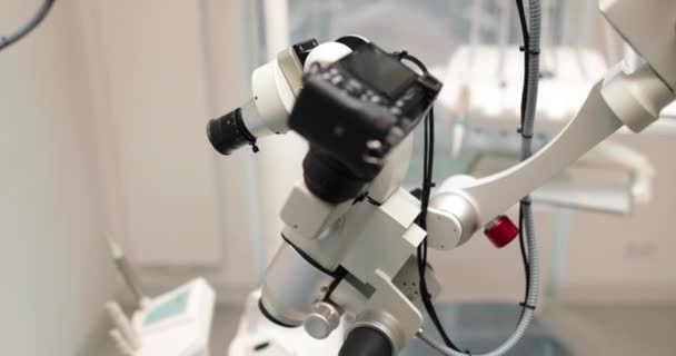 Close-up view of dental microscope indoors in medical clinic without people. Professional equipment with changing magnification and lens in a dental office in a hospital - Footage, Video