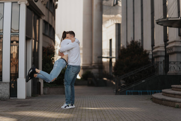 Primer plano de la hermosa pareja abrazándose mientras está de pie en el centro de la ciudad - Foto, imagen