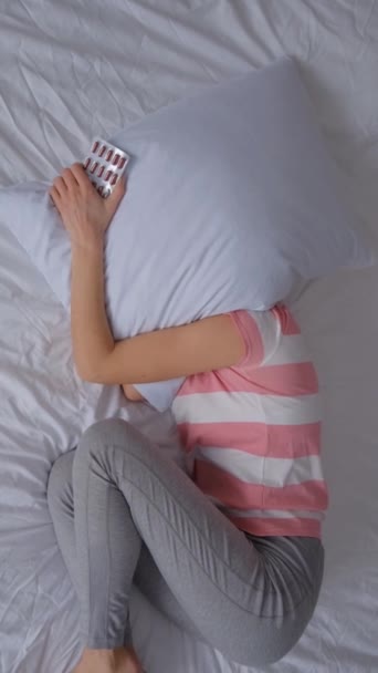 Vrouw voelt angst en symptomen van depressie terwijl ze in bed ligt. Geestelijke gezondheid. Verticale video - Video