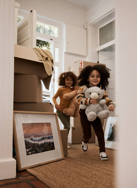 Girl, children and happy in new home, running and toys with game, moving and excited for new beginning. Kids, teddy bear and playful with games at door in apartment, family house and freedom in lobby. - Photo, Image