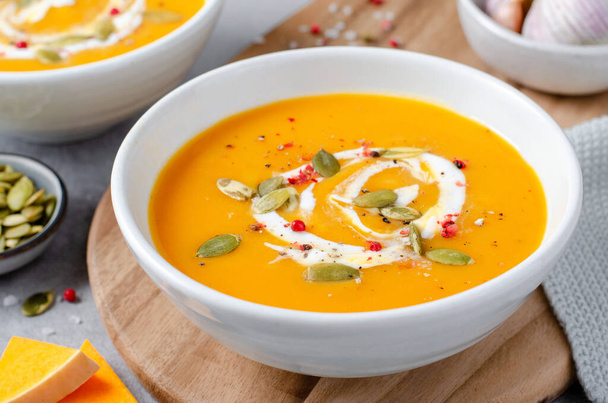 Тыквенный суп, вкусная домашняя тыква, сладкий картофель или морковный суп в миске на ярком фоне - Фото, изображение